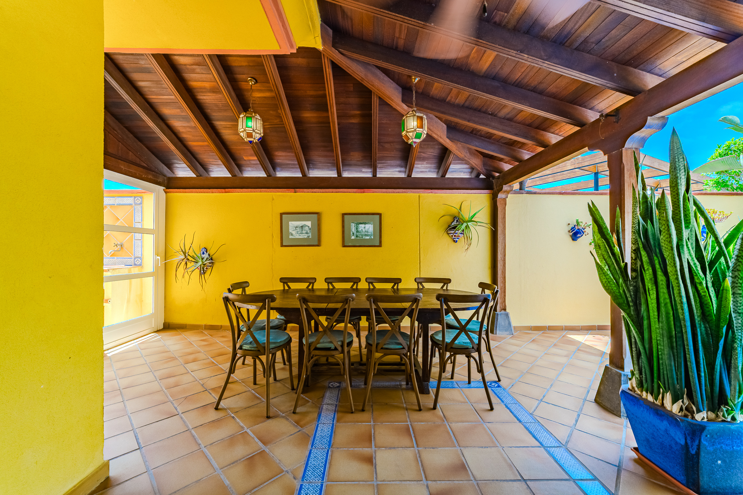 Dining table for ten under the wooden roof beside the pool